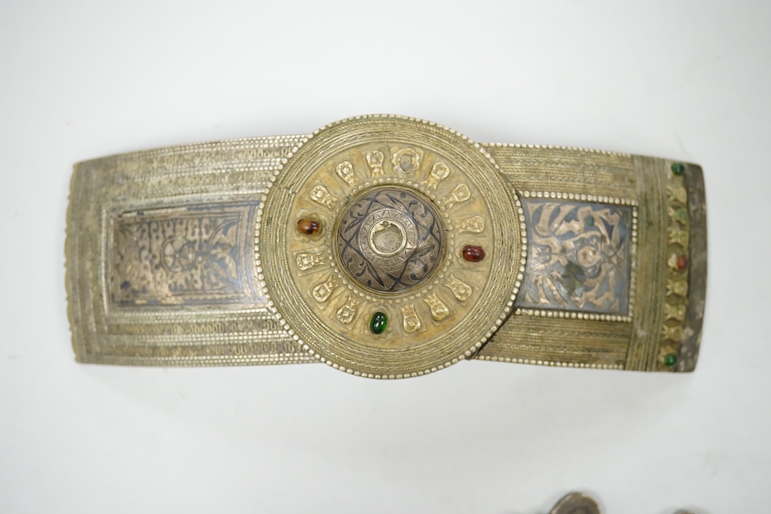A niello work belt buckle, 21cm wide, an Arab white metal cloak brooch and a powder flask